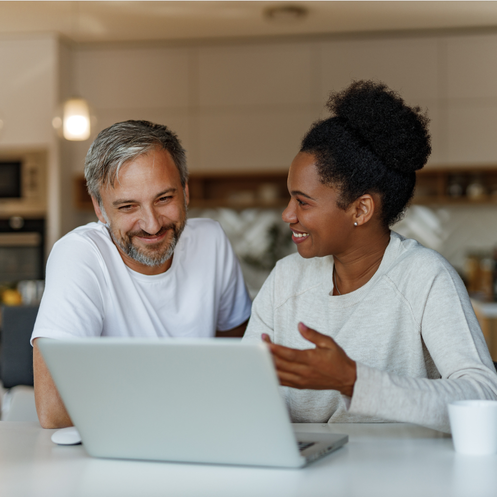 Midlife couple working together on a laptop, highlighting the importance of Split It or Share It: Navigating Finances and Relationships in Midlife.